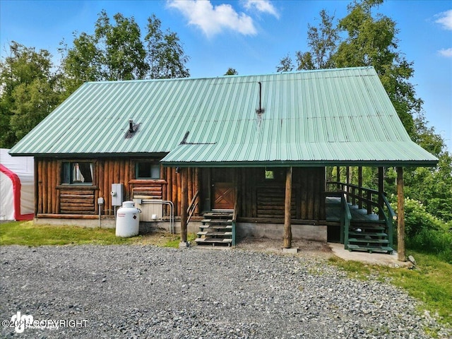 22032 Spring Creek Ln, Chugiak, AK 99567 - view of front of house with a metal roof, log exterior, and an exterior structure