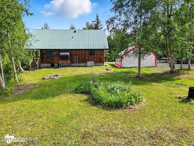 22032 Spring Creek Ln, Chugiak, AK 99567 - rear view of house with a lawn, a deck, and a metal roof