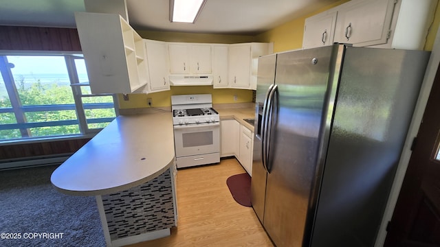 22032 Spring Creek Ln, Chugiak, AK 99567 - kitchen with stainless steel fridge, white gas range, under cabinet range hood, light countertops, and a baseboard heating unit