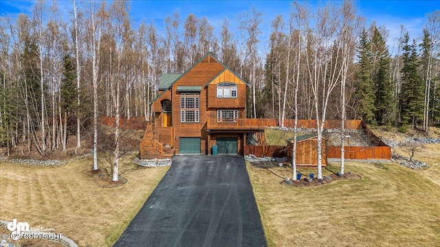 view of front of house featuring a front lawn, stairway, aphalt driveway, and a garage