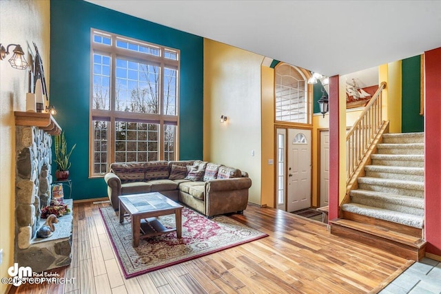 living room with wood finished floors, a high ceiling, and stairs