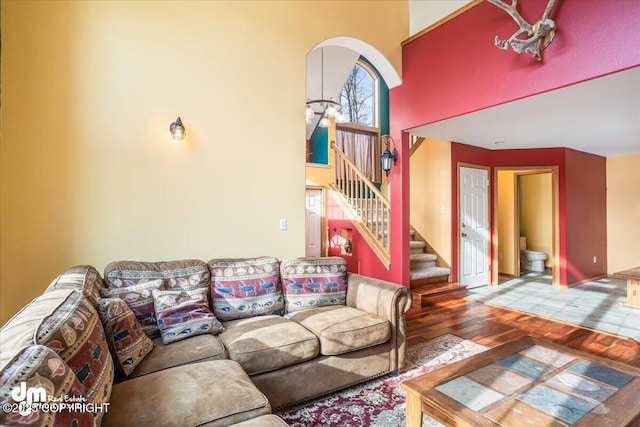 living area featuring stairs, a high ceiling, and wood finished floors