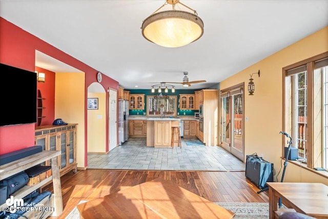 kitchen featuring light countertops, glass insert cabinets, light wood-style flooring, and a center island