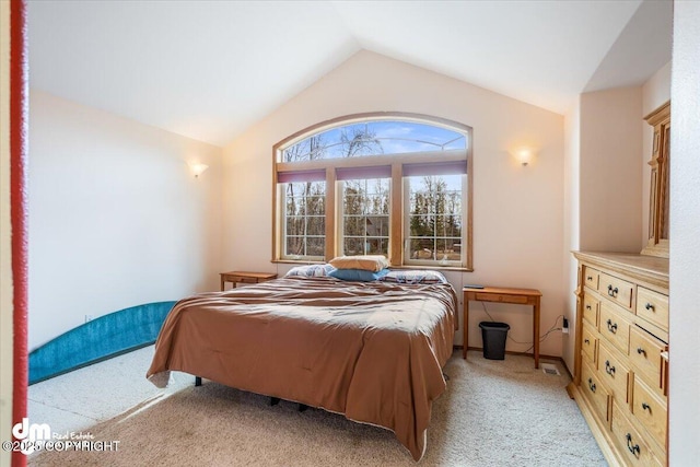 bedroom with vaulted ceiling and light colored carpet