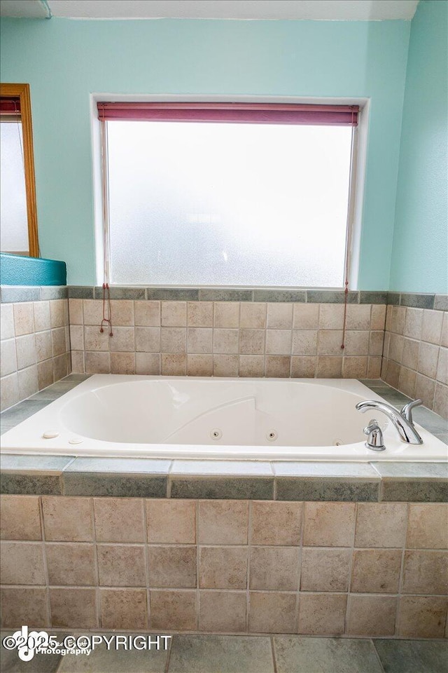 bathroom with a tub with jets and a healthy amount of sunlight