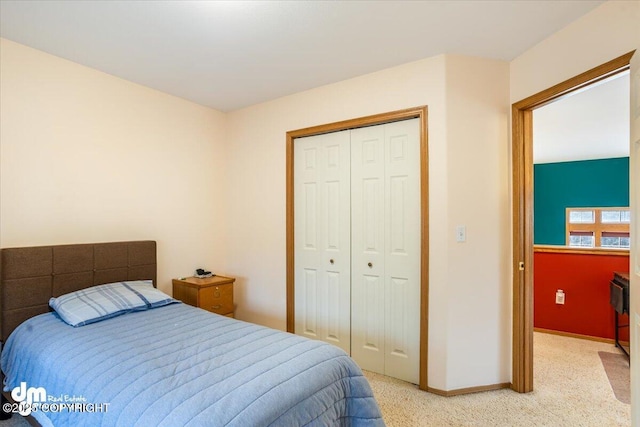 bedroom featuring baseboards, light carpet, and a closet