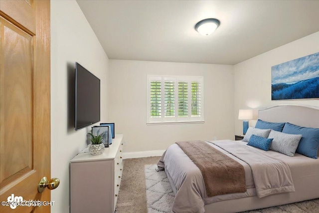 bedroom featuring light colored carpet and baseboards