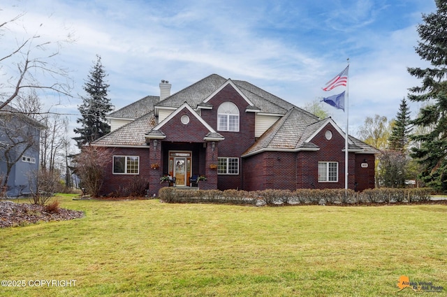 traditional-style house with brick siding, a front lawn, and a chimney