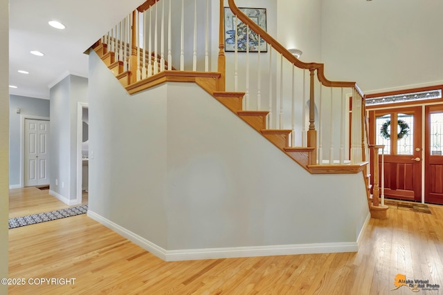 foyer with baseboards, wood finished floors, stairs, recessed lighting, and ornamental molding