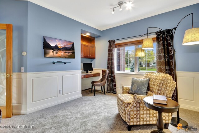 sitting room with carpet, wainscoting, a decorative wall, and ornamental molding