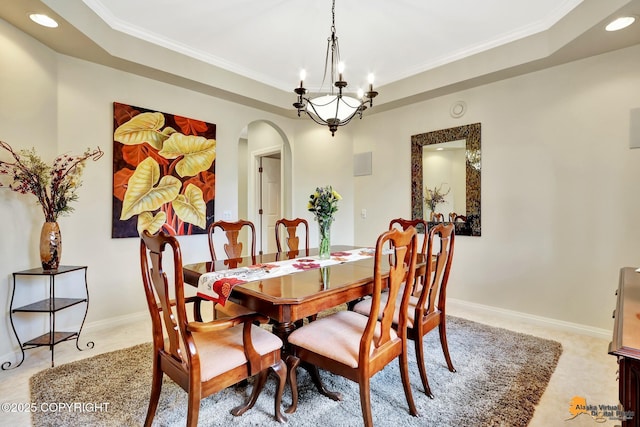 dining area with arched walkways, a raised ceiling, recessed lighting, ornamental molding, and a chandelier