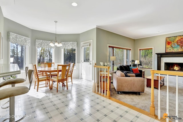 dining room with a chandelier, ornamental molding, a tiled fireplace, and recessed lighting