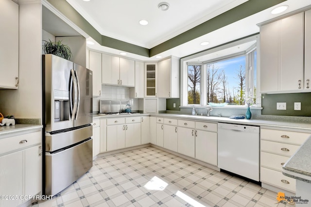 kitchen featuring white appliances, light flooring, a sink, ornamental molding, and light countertops