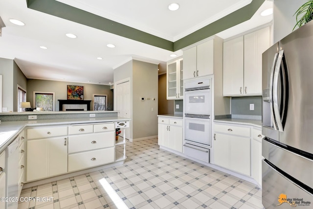 kitchen with stainless steel fridge, ornamental molding, a warming drawer, recessed lighting, and light countertops
