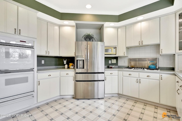 kitchen featuring white appliances, light countertops, a warming drawer, light flooring, and crown molding