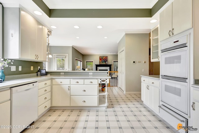 kitchen featuring white appliances, a warming drawer, a peninsula, light countertops, and light floors