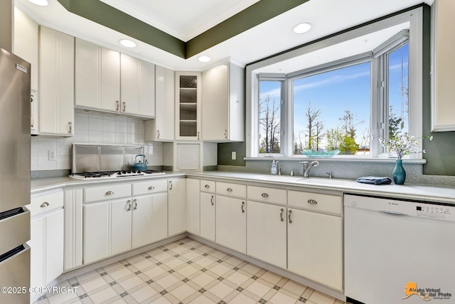 kitchen with white appliances, a sink, light countertops, light floors, and decorative backsplash