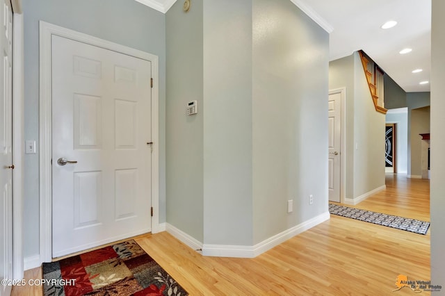 foyer entrance featuring light wood-style floors, crown molding, baseboards, and recessed lighting