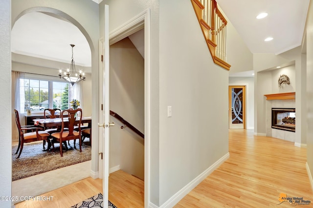 hallway with light wood-type flooring, a chandelier, recessed lighting, and baseboards