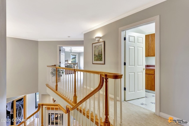 hall featuring an upstairs landing, light colored carpet, crown molding, and baseboards