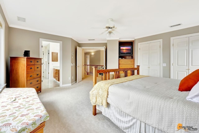 bedroom with two closets, ornamental molding, light colored carpet, baseboards, and ensuite bath