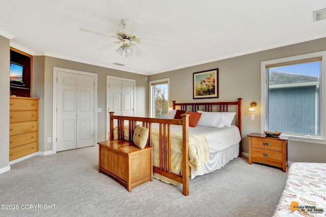 bedroom featuring light carpet, multiple closets, multiple windows, and crown molding