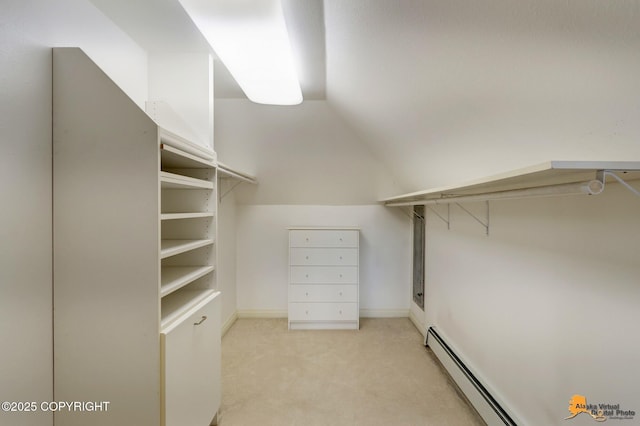 spacious closet featuring baseboard heating, carpet, and lofted ceiling