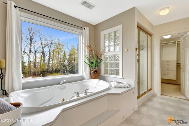 full bath with a jetted tub, a stall shower, and tile patterned floors