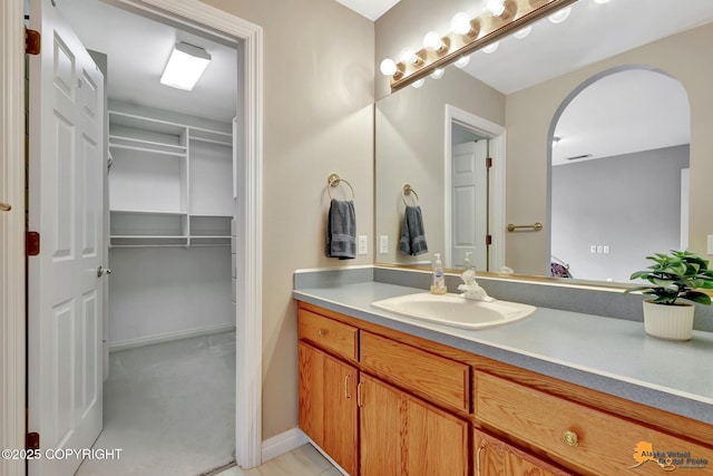 bathroom with vanity and a spacious closet