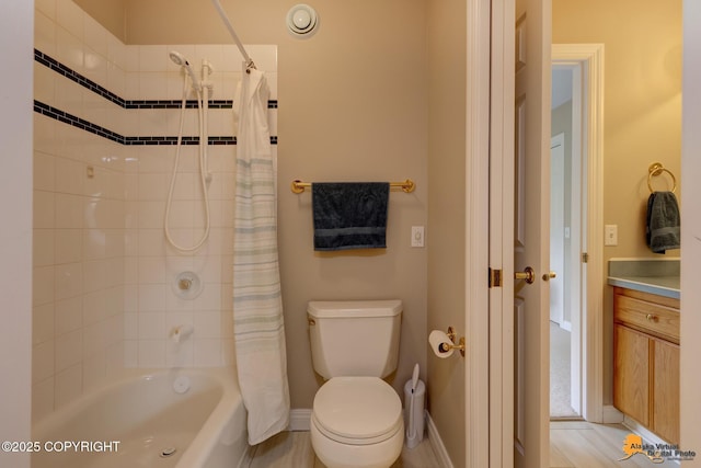 bathroom with shower / bath combination with curtain, toilet, baseboards, and vanity