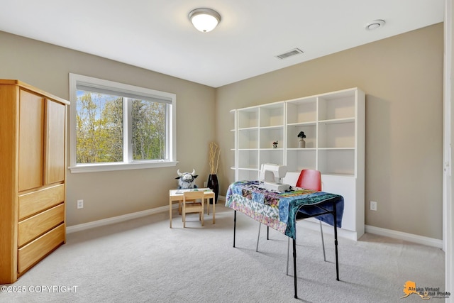 bedroom with light colored carpet, baseboards, and an office area