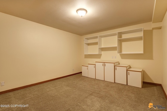 unfurnished room featuring light carpet and baseboards
