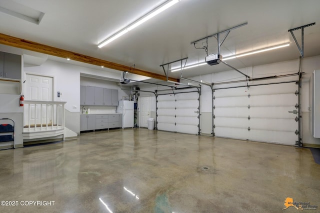 garage with a garage door opener and freestanding refrigerator