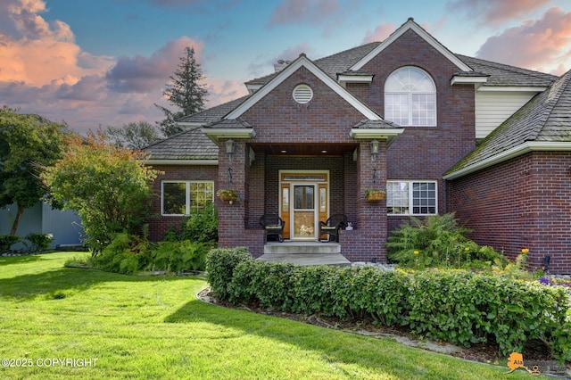 traditional-style home featuring brick siding and a front lawn