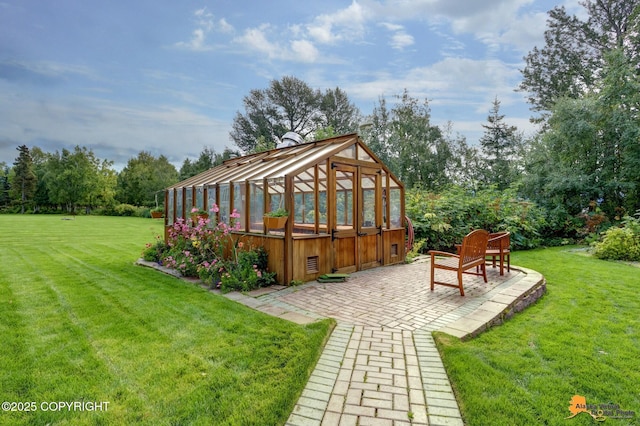 view of green lawn featuring an exterior structure, a patio area, an outbuilding, and view of scattered trees