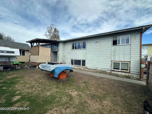 rear view of property featuring a yard