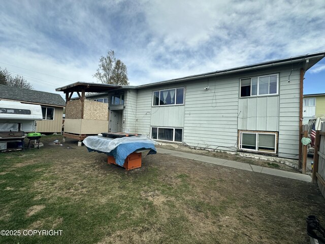 back of house featuring a lawn