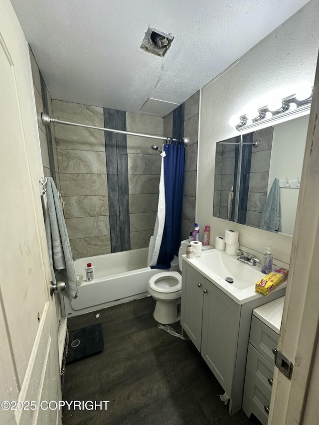 full bathroom with a textured ceiling, vanity, shower / tub combo with curtain, toilet, and wood finished floors