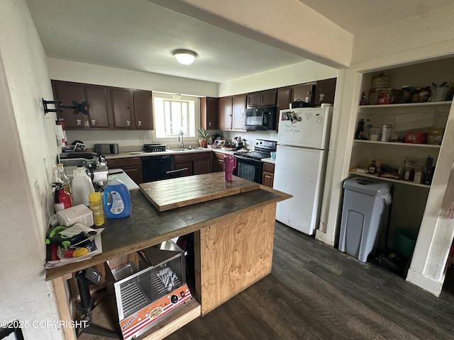 kitchen featuring black appliances, a sink, dark brown cabinets, dark wood finished floors, and a peninsula