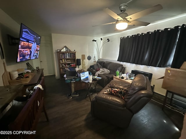 living area featuring dark wood-type flooring and a ceiling fan