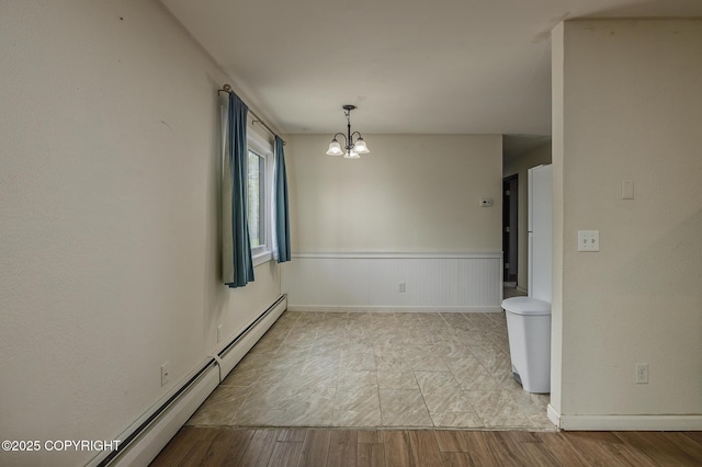 8516 Boundary Ave # E3, Anchorage, AK 99504 - unfurnished room featuring a chandelier, wood finished floors, baseboard heating, wainscoting, and baseboards