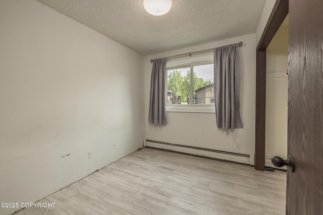 8516 Boundary Ave # E3, Anchorage, AK 99504 - empty room with baseboard heating, a textured ceiling, and light wood-type flooring