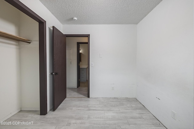 8516 Boundary Ave # E3, Anchorage, AK 99504 - unfurnished bedroom featuring a textured ceiling, a closet, and light wood-type flooring