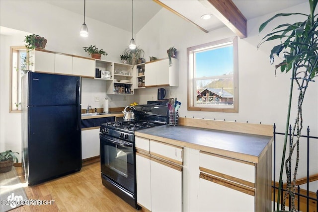 kitchen with black appliances, a sink, white cabinets, light wood finished floors, and beamed ceiling