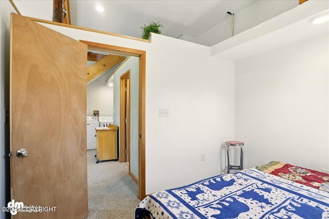 bedroom featuring washing machine and clothes dryer and light colored carpet