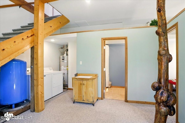 interior space with washing machine and clothes dryer, a water pressure tank, water heater, carpet, and stairway