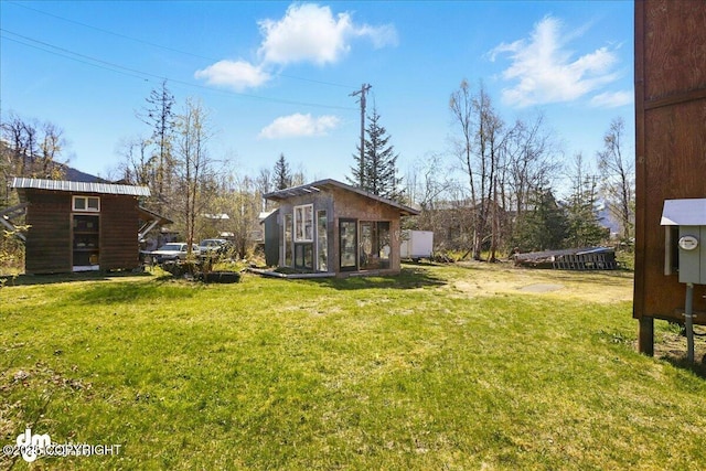 view of grassy yard with an outbuilding and exterior structure