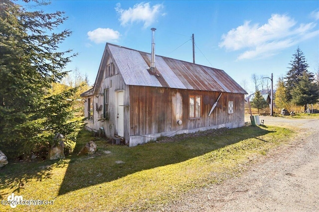 view of side of property with a yard and driveway