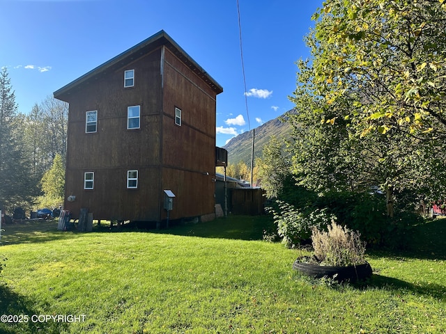 view of side of property featuring a yard and a mountain view