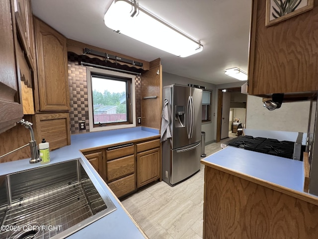 7700 Dover Ave, Anchorage, AK 99504 - kitchen featuring stainless steel appliances, brown cabinets, and light countertops